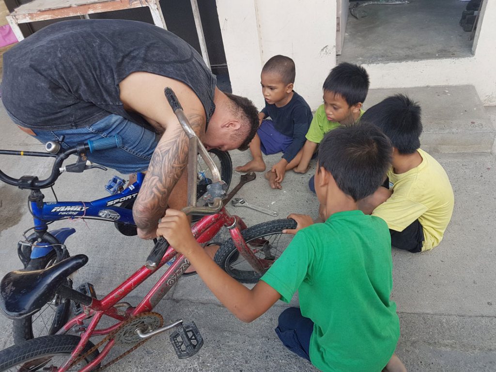 volunteer fixing bike for kids